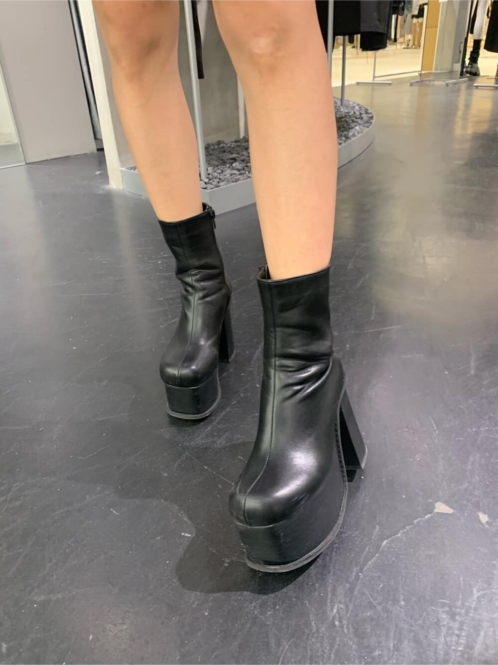 グレー系のスウェット、ブルー系のスカート、ブラック系のブーツを着用したレディースの秋コーディネートの7枚目の写真