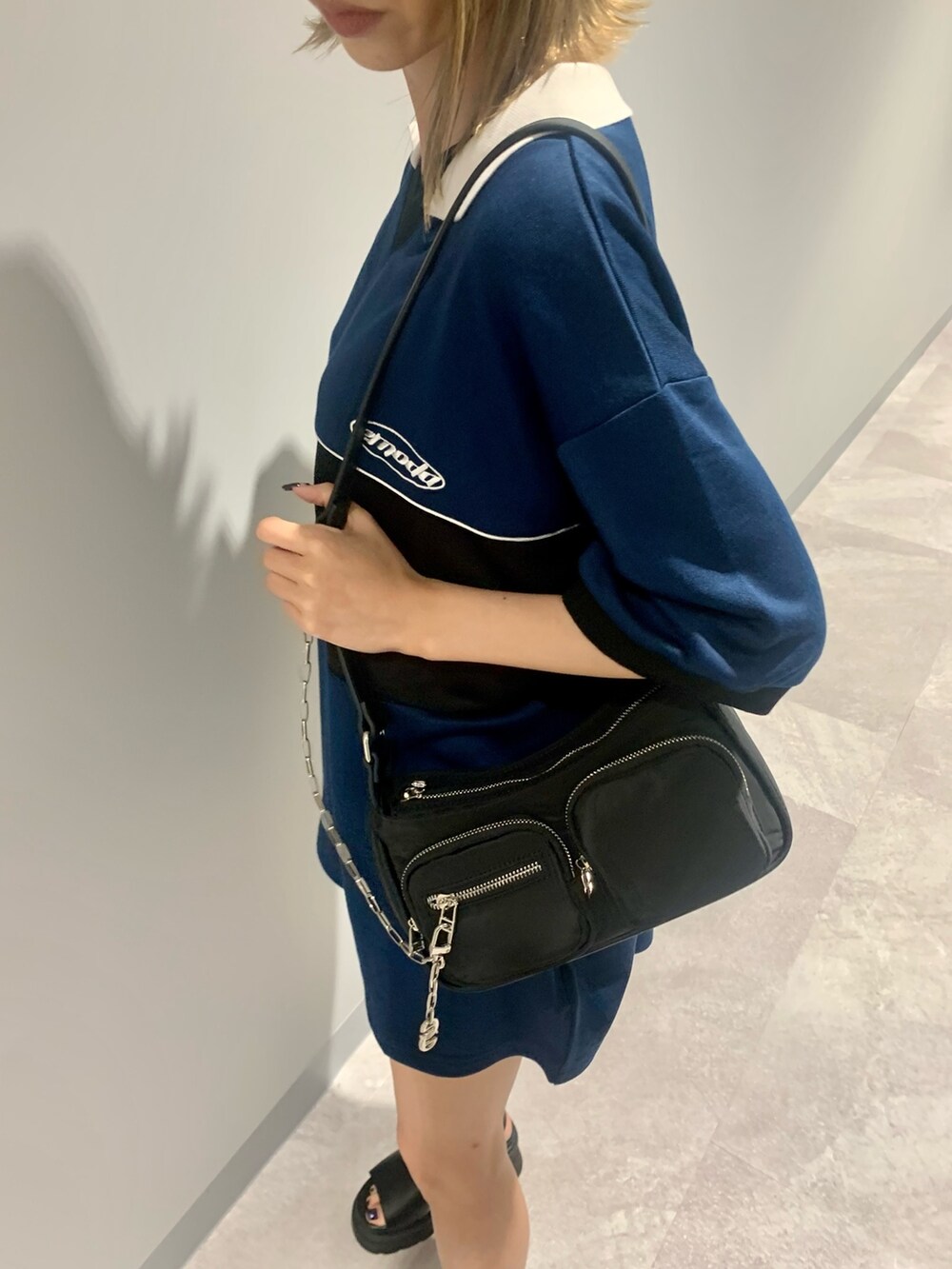 ブルー系のTシャツ/カットソー、ブラック系のハンドバッグ、ブラック系のサンダルを着用したレディースの夏コーディネートの4枚目の写真