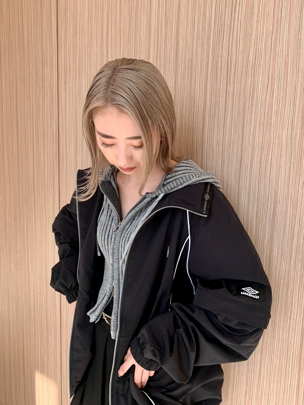 ブラック系のスカート、グレー系のワンピース、ブラック系のブルゾンを着用したレディースの春コーディネートの5枚目の写真