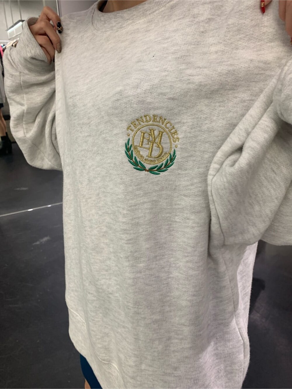 グレー系のスウェット、ブルー系のスカート、ブラック系のブーツを着用したレディースの秋コーディネートの5枚目の写真