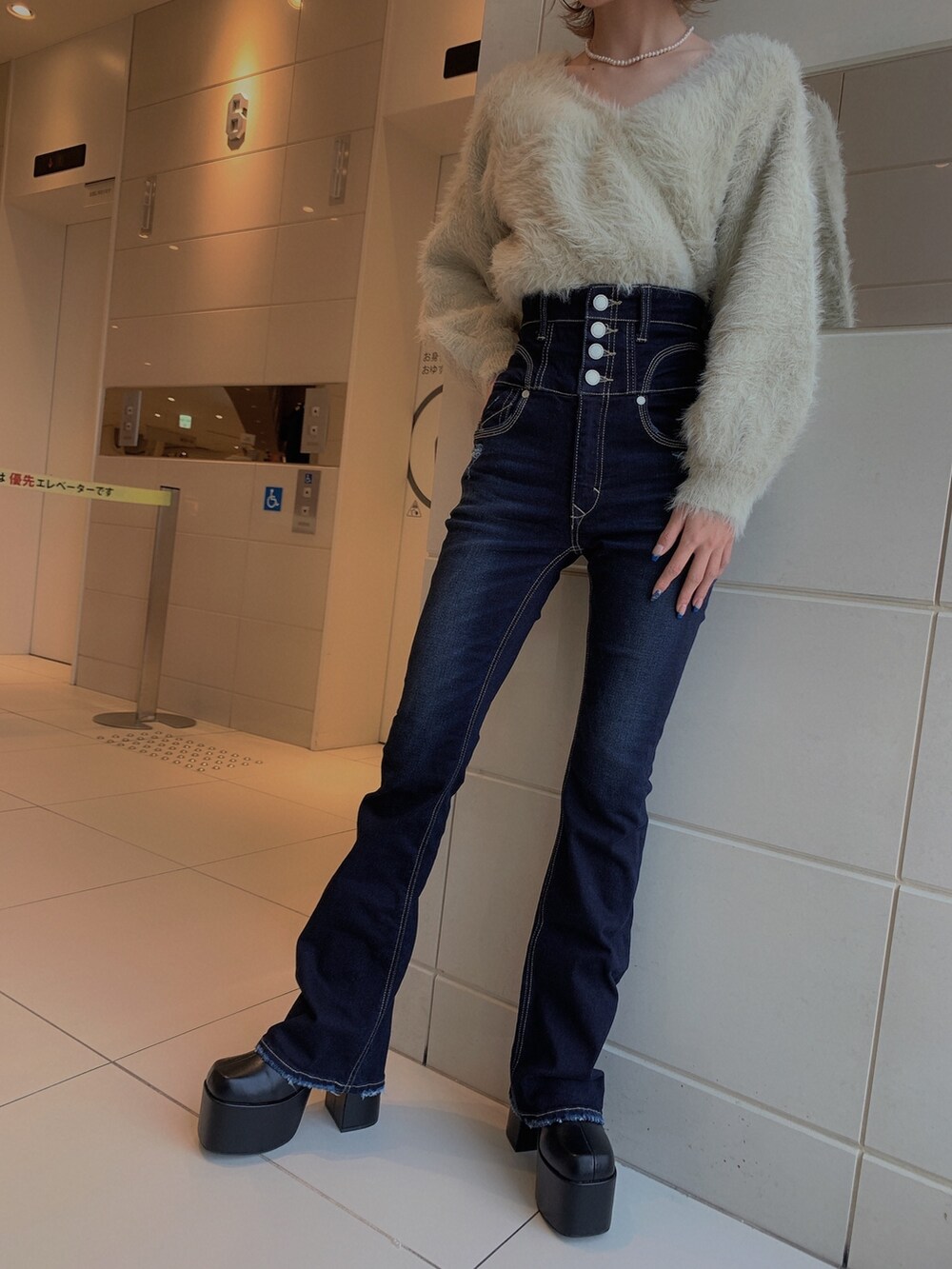 グレー系のニット/セーター、ブルー系のデニムパンツ、ブラック系のブーツを着用したレディースの冬コーディネートの8枚目の写真