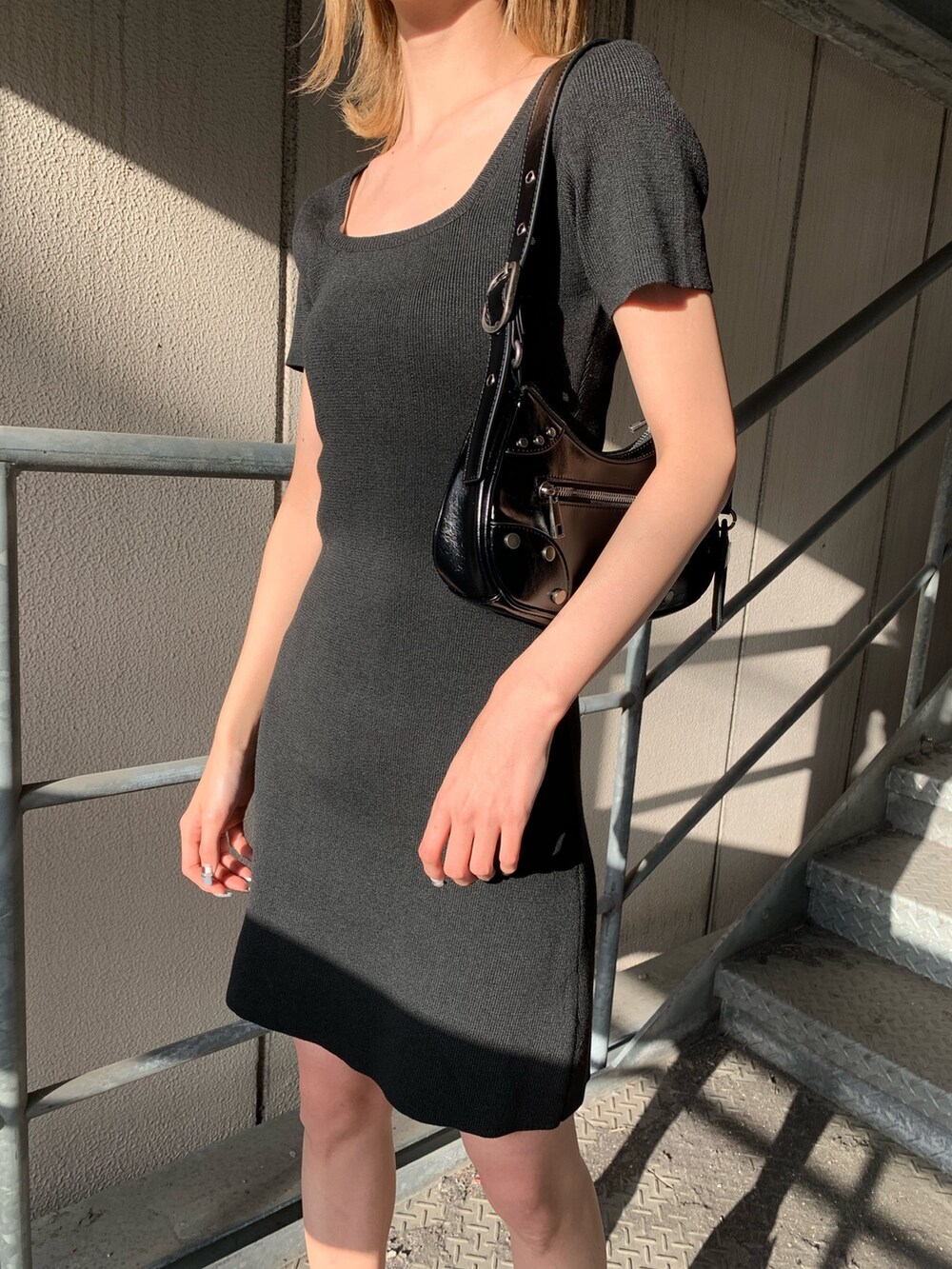 ブラック系のワンピース、ブラック系のサンダル、ブラック系のハンドバッグを着用したレディースの春コーディネートの8枚目の写真