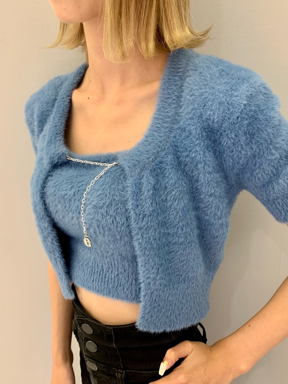 ブラック系のデニムパンツ、ブルー系のニット/セーター、シルバー系のハンドバッグを着用したレディースの夏コーディネートの5枚目の写真