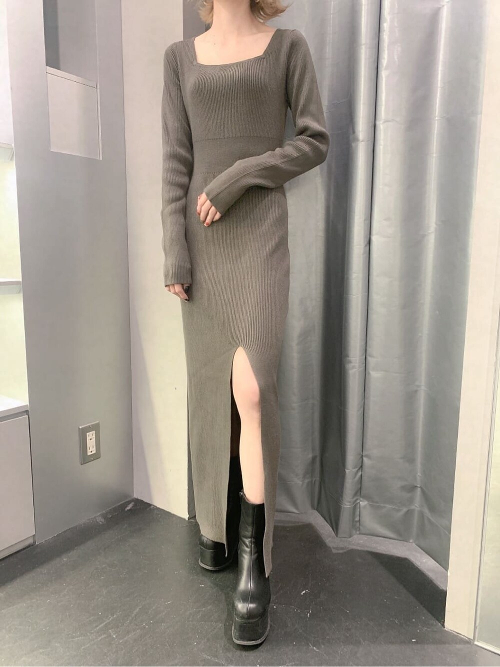 ブラック系のブーツ、グレー系のワンピース、ゴールド系のピアス（両耳用）を着用したレディースの秋コーディネートの9枚目の写真