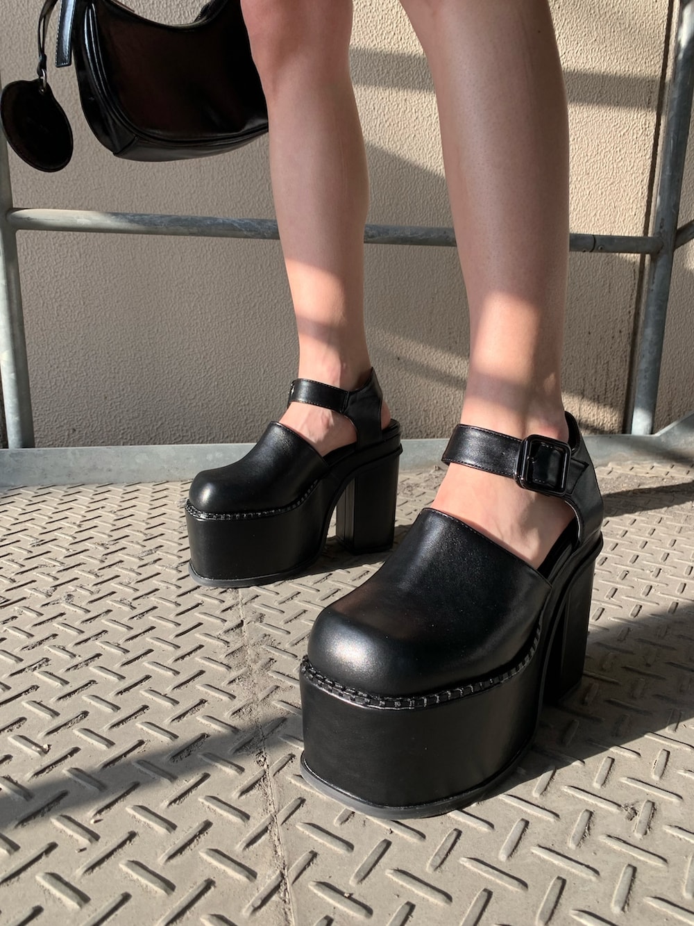 ブラック系のワンピース、ブラック系のサンダル、ブラック系のハンドバッグを着用したレディースの春コーディネートの9枚目の写真