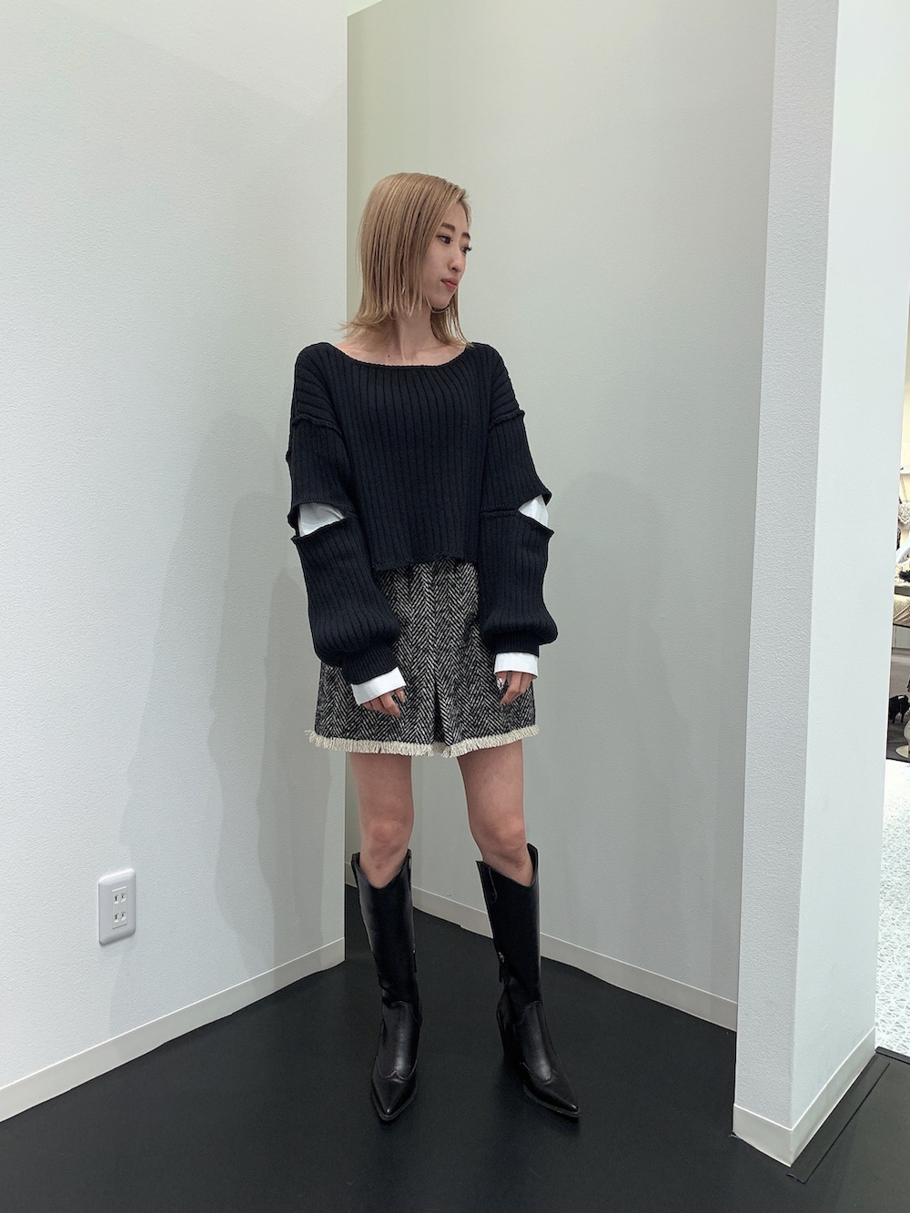 ブラック系のニット/セーター、ブラック系のブーツを着用したレディースの冬コーディネートの3枚目の写真