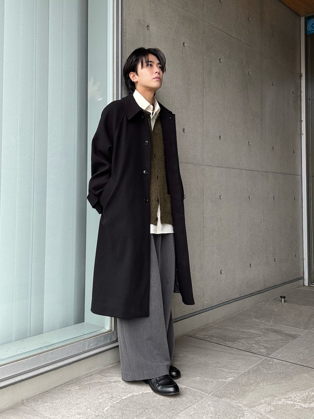 グリーン系のカーディガン/ボレロ、ホワイト系のシャツ/ブラウス、グレー系のスラックスを着用したメンズの冬コーディネートの2枚目の写真