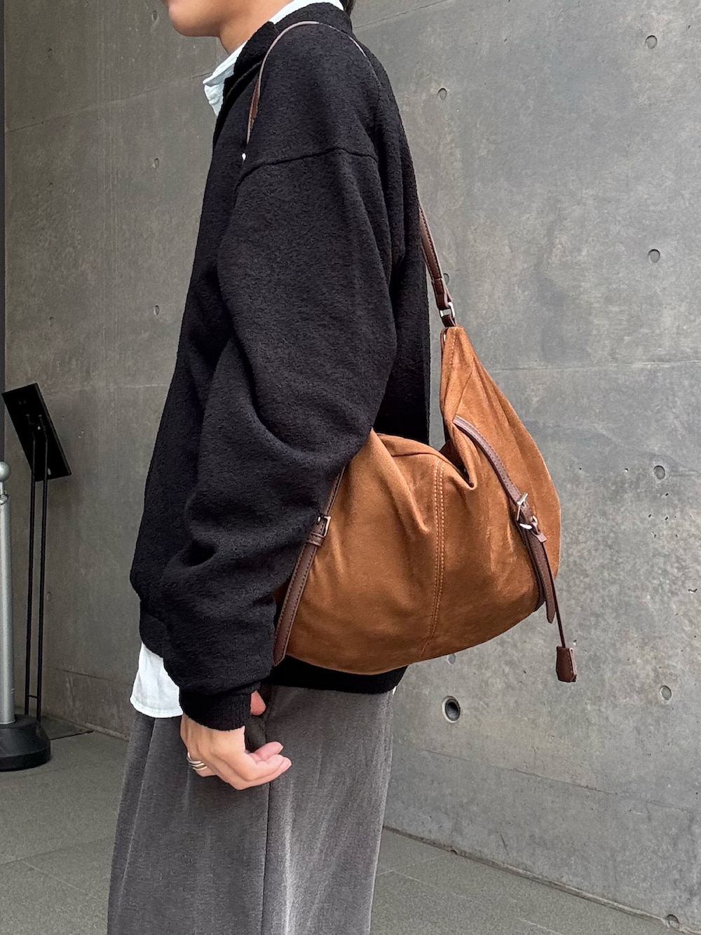 ブラック系のニット/セーター、ブルー系のシャツ/ブラウス、グレー系のスラックスを着用したメンズの春コーディネートの2枚目の写真