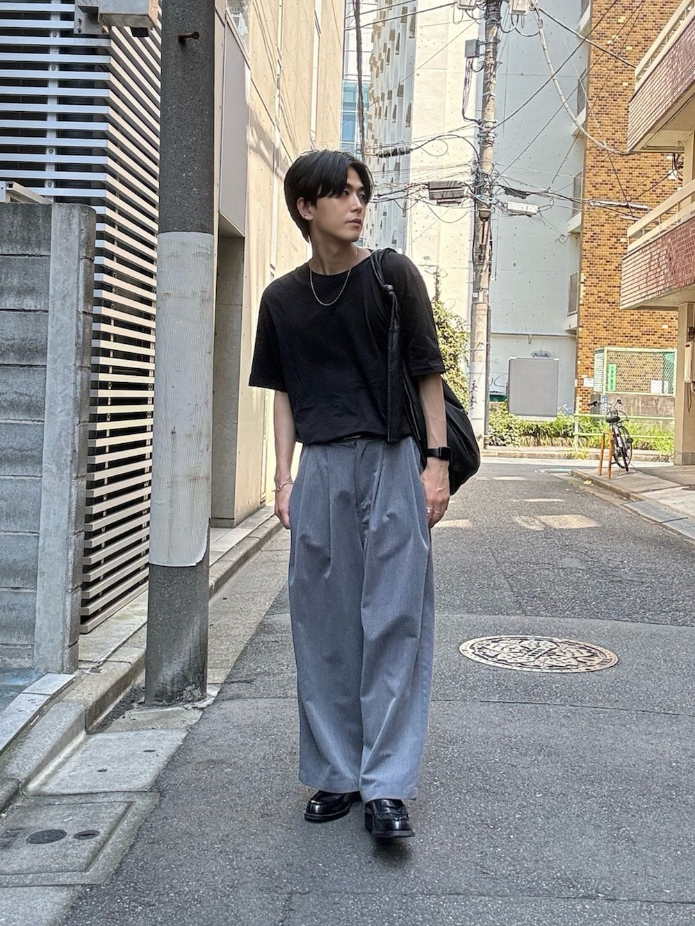 ブラック系のローファー、ブラック系のTシャツ/カットソー、ブラック系のショルダーバッグを着用したメンズの夏コーディネートの2枚目の写真