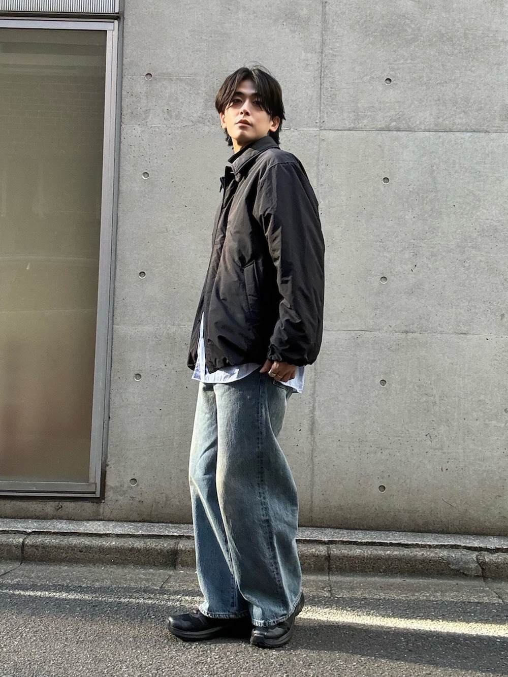 ブルー系のシャツ/ブラウス、ブラック系のブルゾン、ブルー系のデニムパンツを着用したメンズの冬コーディネートの2枚目の写真