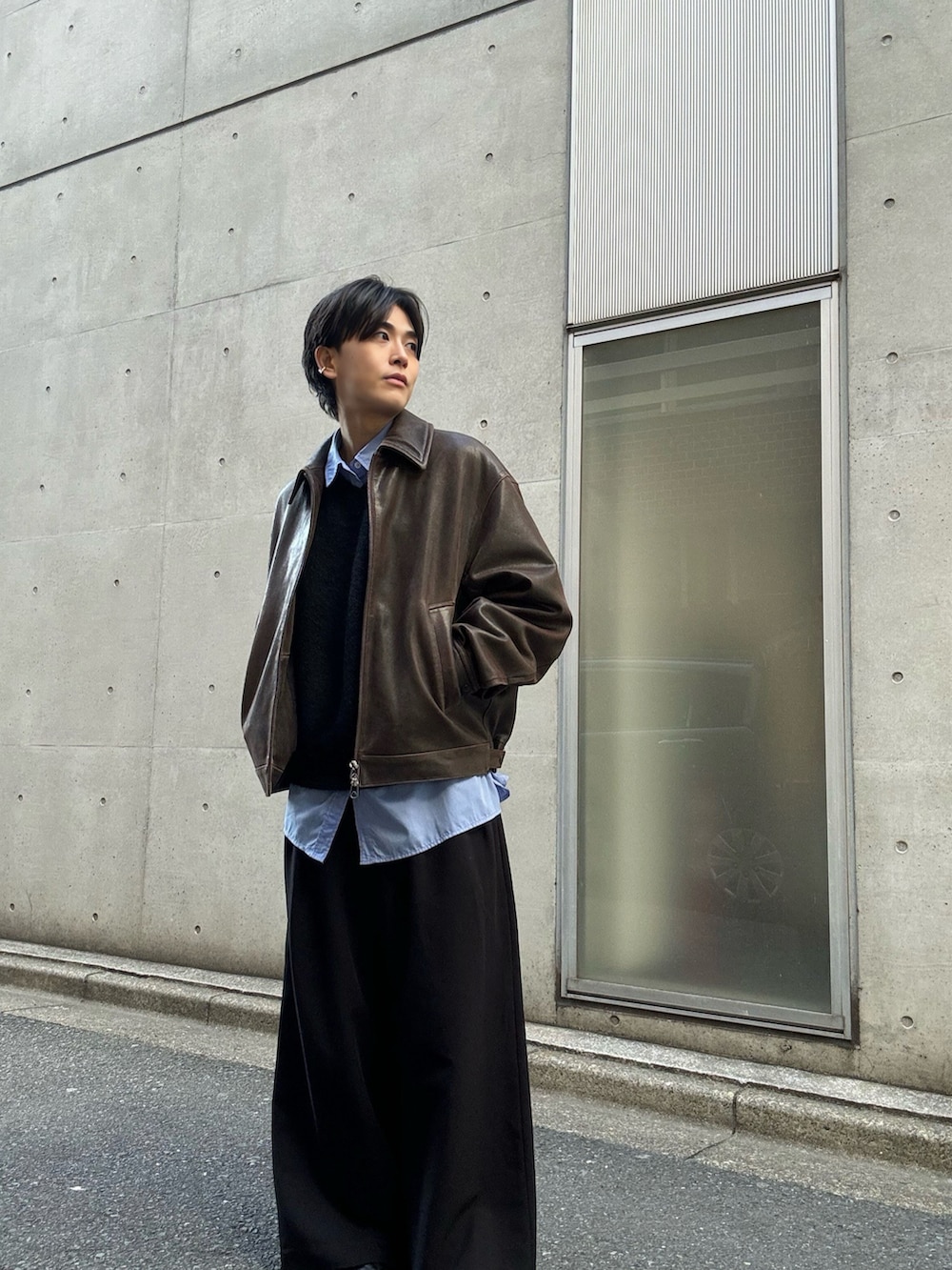 ブラック系のニット/セーター、ブルー系のシャツ/ブラウス、ブラック系のスラックスを着用したメンズの冬コーディネートの2枚目の写真