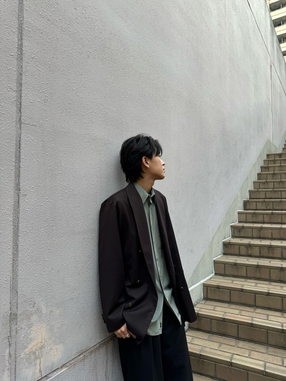 ブラック系のスラックス、ブラック系のローファー、グリーン系のシャツ/ブラウスを着用したメンズの春コーディネートの2枚目の写真