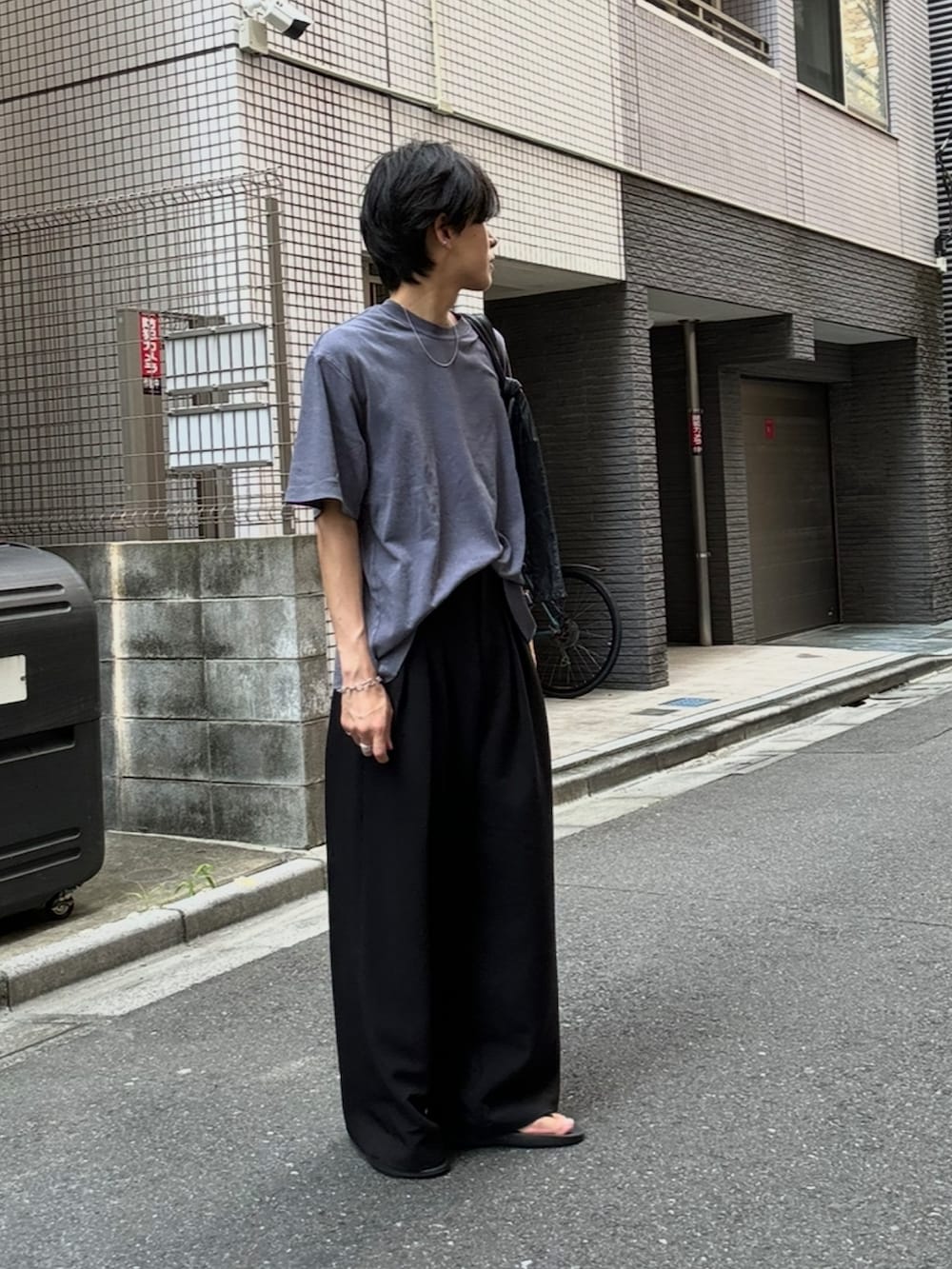 ブラック系のスラックス、ブラック系のサンダル、ブルー系のTシャツ/カットソーを着用したメンズの夏コーディネートの3枚目の写真