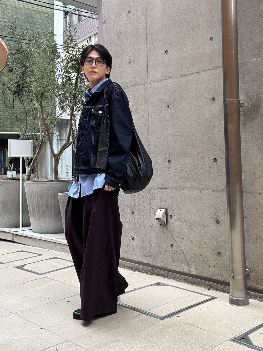 ブルー系のシャツ/ブラウス、ブラウン系のスラックス、ブラック系のショルダーバッグを着用したメンズの春コーディネートの2枚目の写真