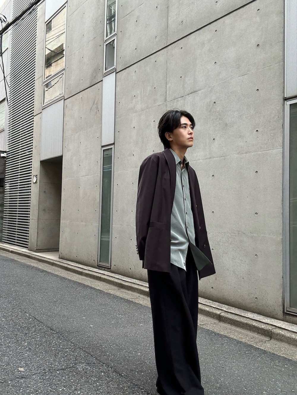 ブラック系のスラックス、ブラック系のローファー、グリーン系のシャツ/ブラウスを着用したメンズの春コーディネートの3枚目の写真