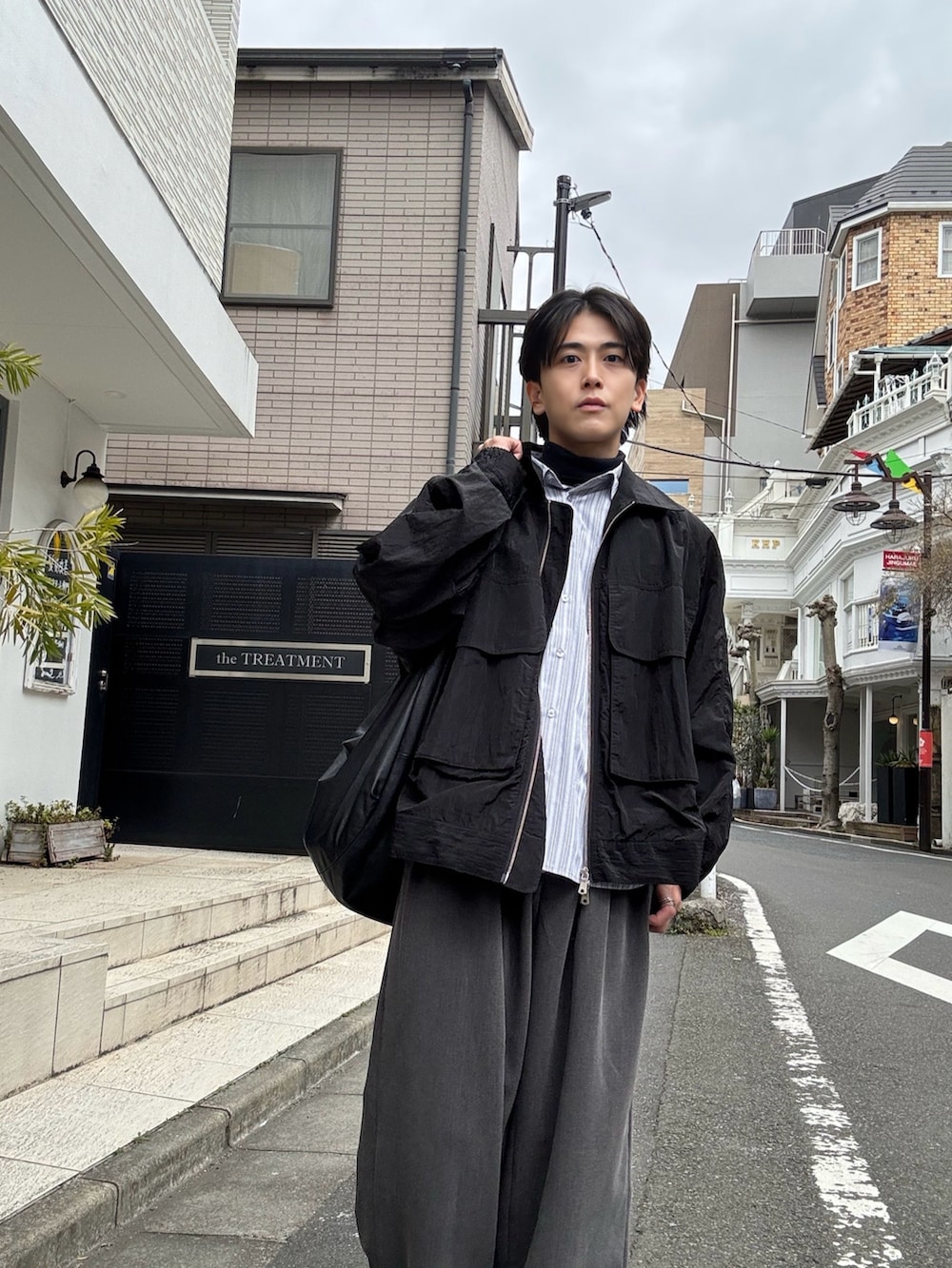 グレー系のシャツ/ブラウス、グレー系のスラックス、ブラック系のショルダーバッグを着用したメンズの春コーディネートの2枚目の写真