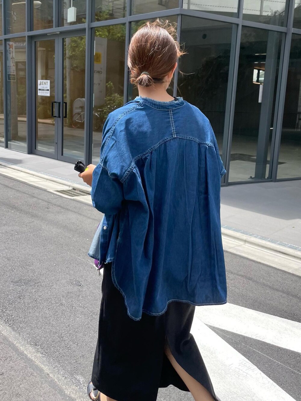 ブルー系のシャツ/ブラウス、ブラック系のジャンパースカート、パープル系のショルダーバッグを着用したレディースの夏コーディネートの2枚目の写真