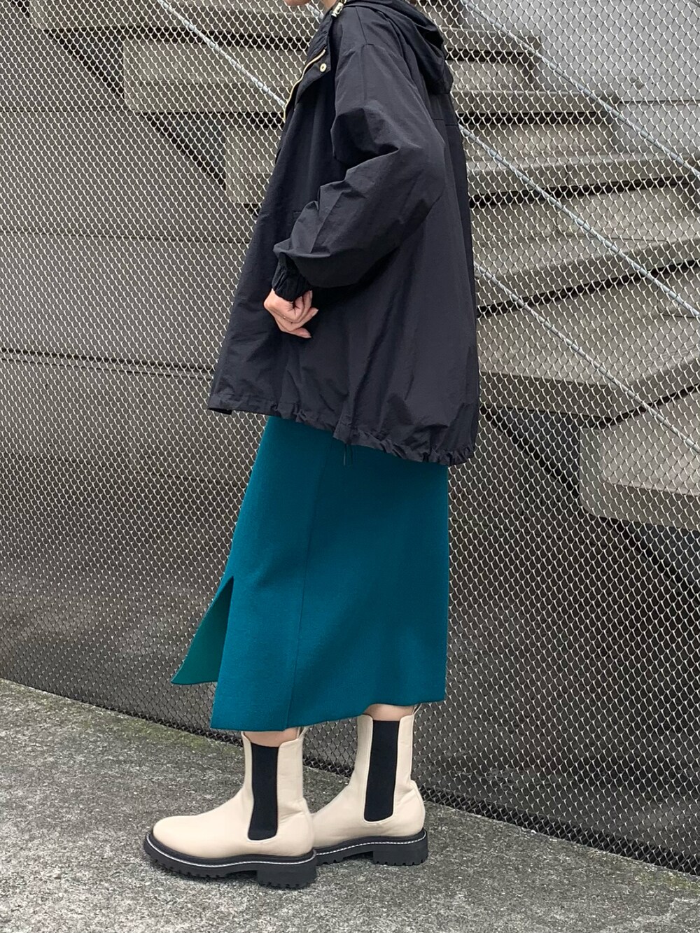 ブラック系のTシャツ/カットソー、ブラック系のマウンテンパーカー、グリーン系のスカートを着用したレディースの秋コーディネートの2枚目の写真