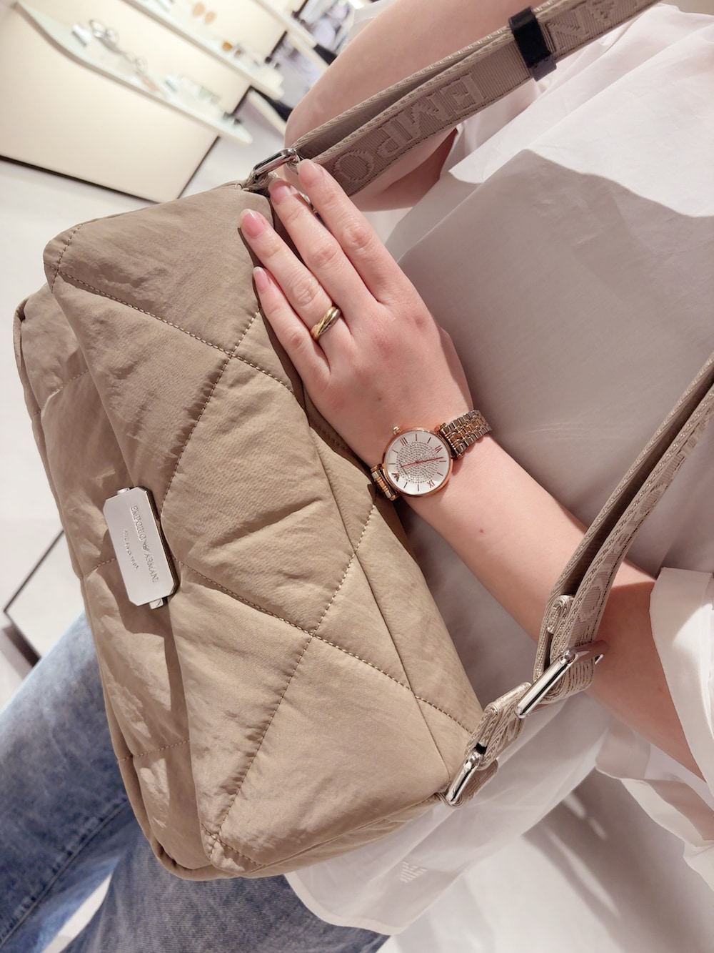 ブルー系のデニムパンツ、ホワイト系のシャツ/ブラウス、ベージュ系のバッグを着用したレディースの春コーディネートの3枚目の写真