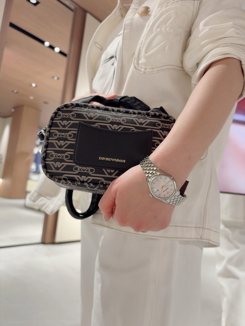 ブラック系のショルダーバッグ、ホワイト系のスニーカー、ホワイト系のTシャツ/カットソーを着用したレディースの春コーディネートの2枚目の写真