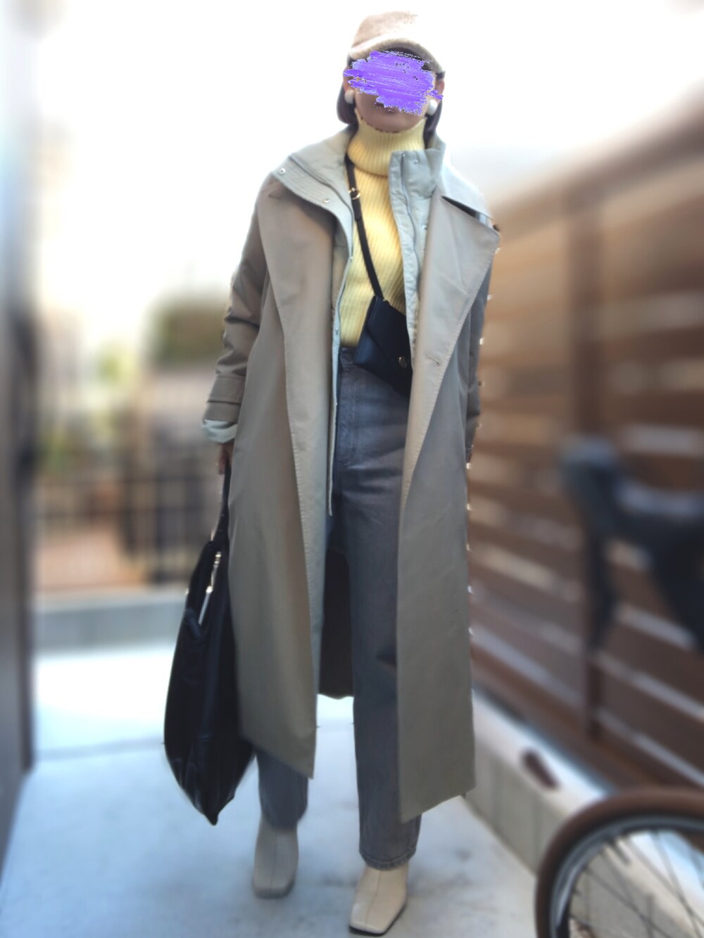 イエロー系のニット/セーター、グレー系のデニムパンツ、グリーン系のダウンジャケット/コートを着用したレディースの冬コーディネートの2枚目の写真