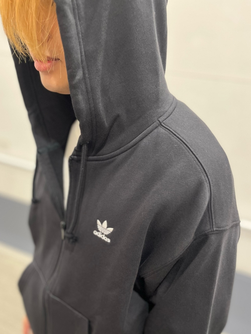 ベージュ系のスニーカー、ブラック系のパーカーを着用したメンズの秋コーディネートの4枚目の写真