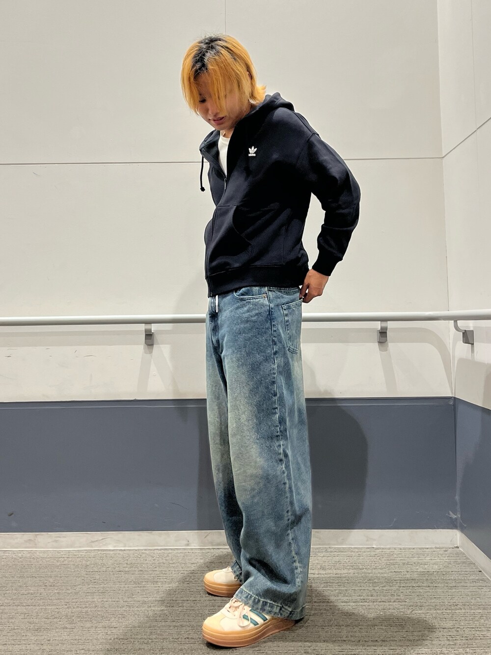 ベージュ系のスニーカー、ブラック系のパーカーを着用したメンズの秋コーディネートの3枚目の写真