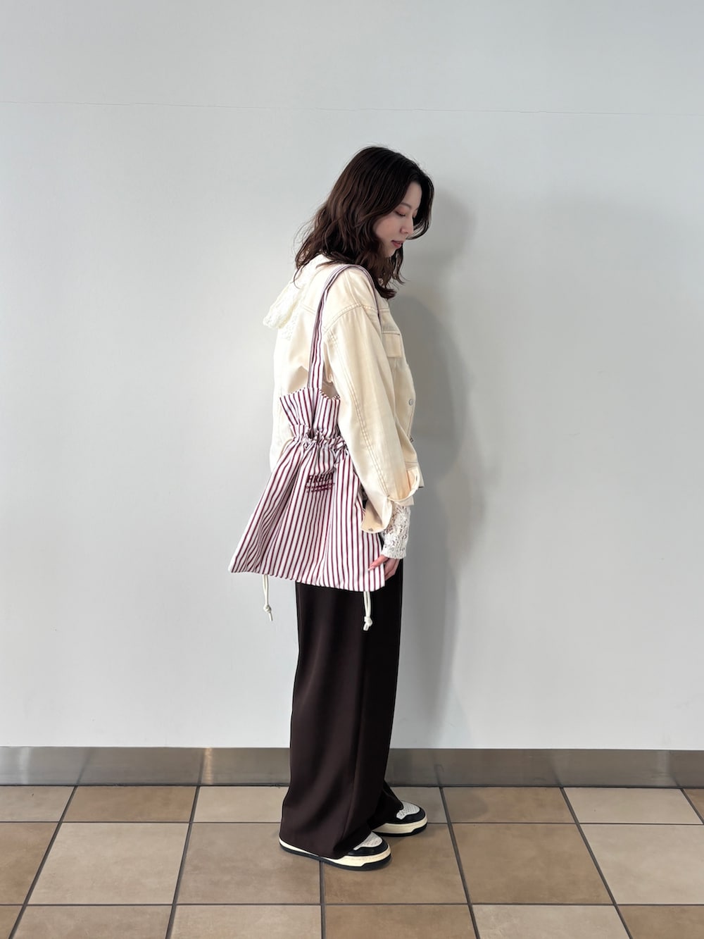 ブラウン系のその他パンツ、ホワイト系のTシャツ/カットソー、ホワイト系のノーカラージャケットを着用したレディースの春コーディネートの2枚目の写真