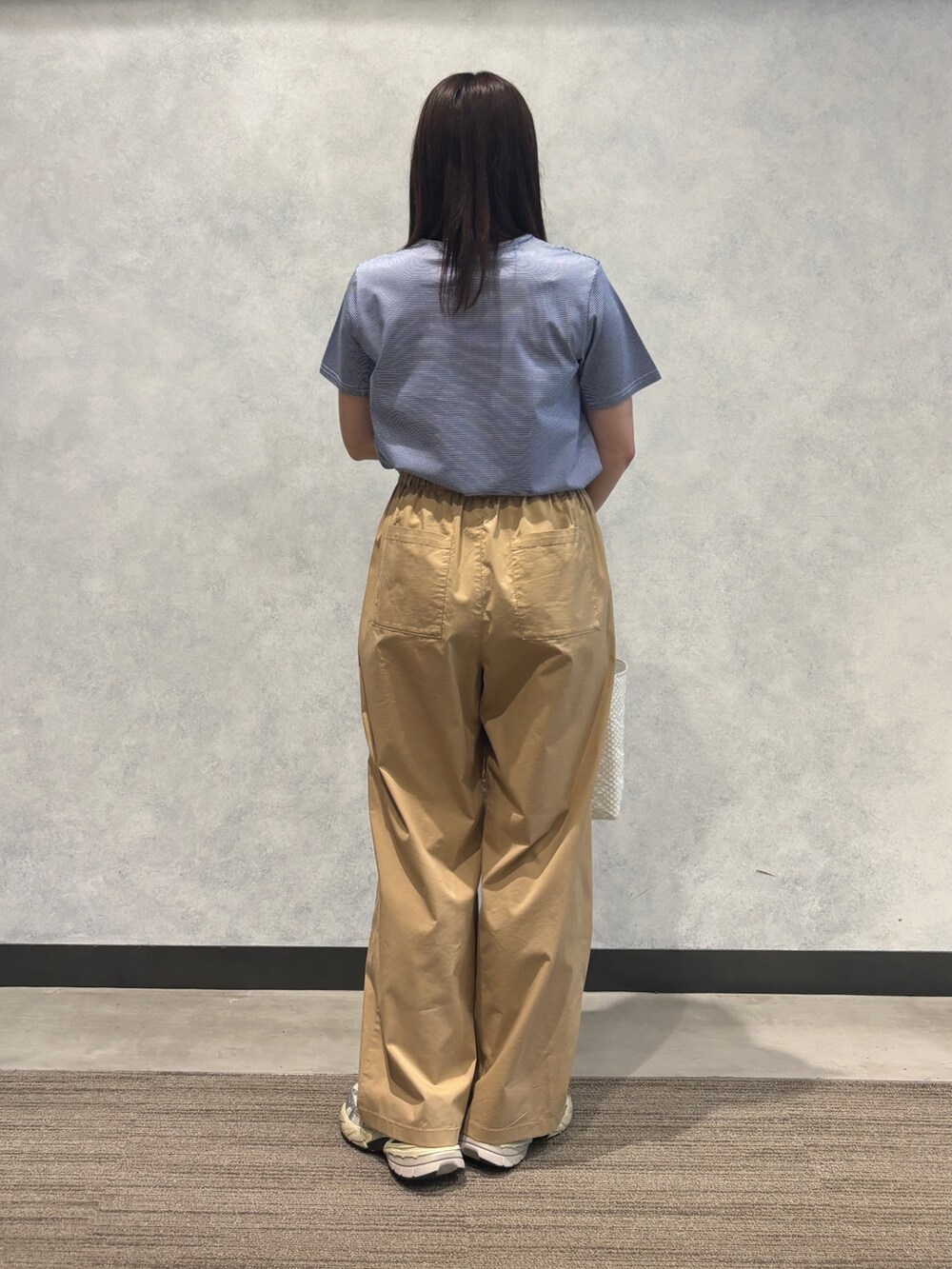 ブルー系のTシャツ/カットソー、ベージュ系のその他パンツ、ホワイト系のかごバッグを着用したレディースの夏コーディネートの2枚目の写真