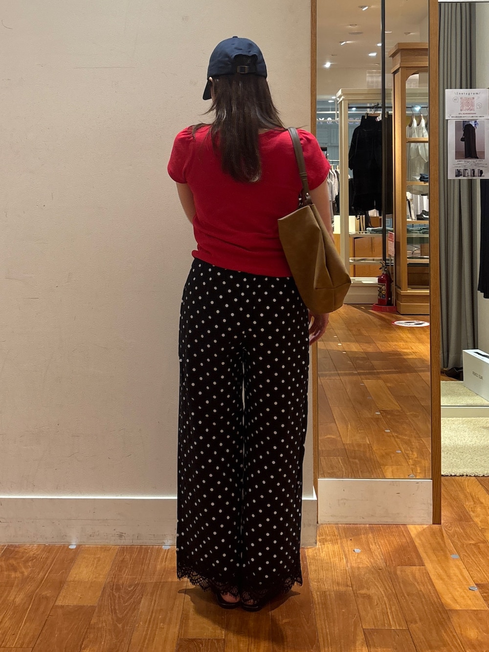 レッド系のTシャツ/カットソー、イエロー系のショルダーバッグ、ブラック系のその他パンツを着用したレディースの夏コーディネートの2枚目の写真