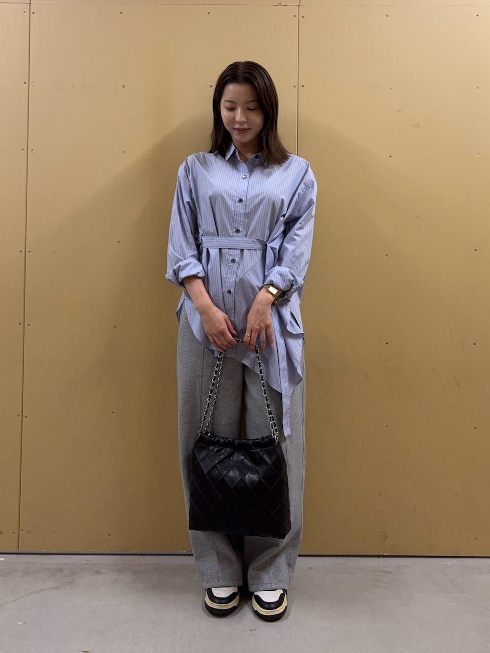 ブルー系のシャツ/ブラウス、グレー系のその他パンツ、ブラック系のショルダーバッグを着用したレディースの秋コーディネートの2枚目の写真