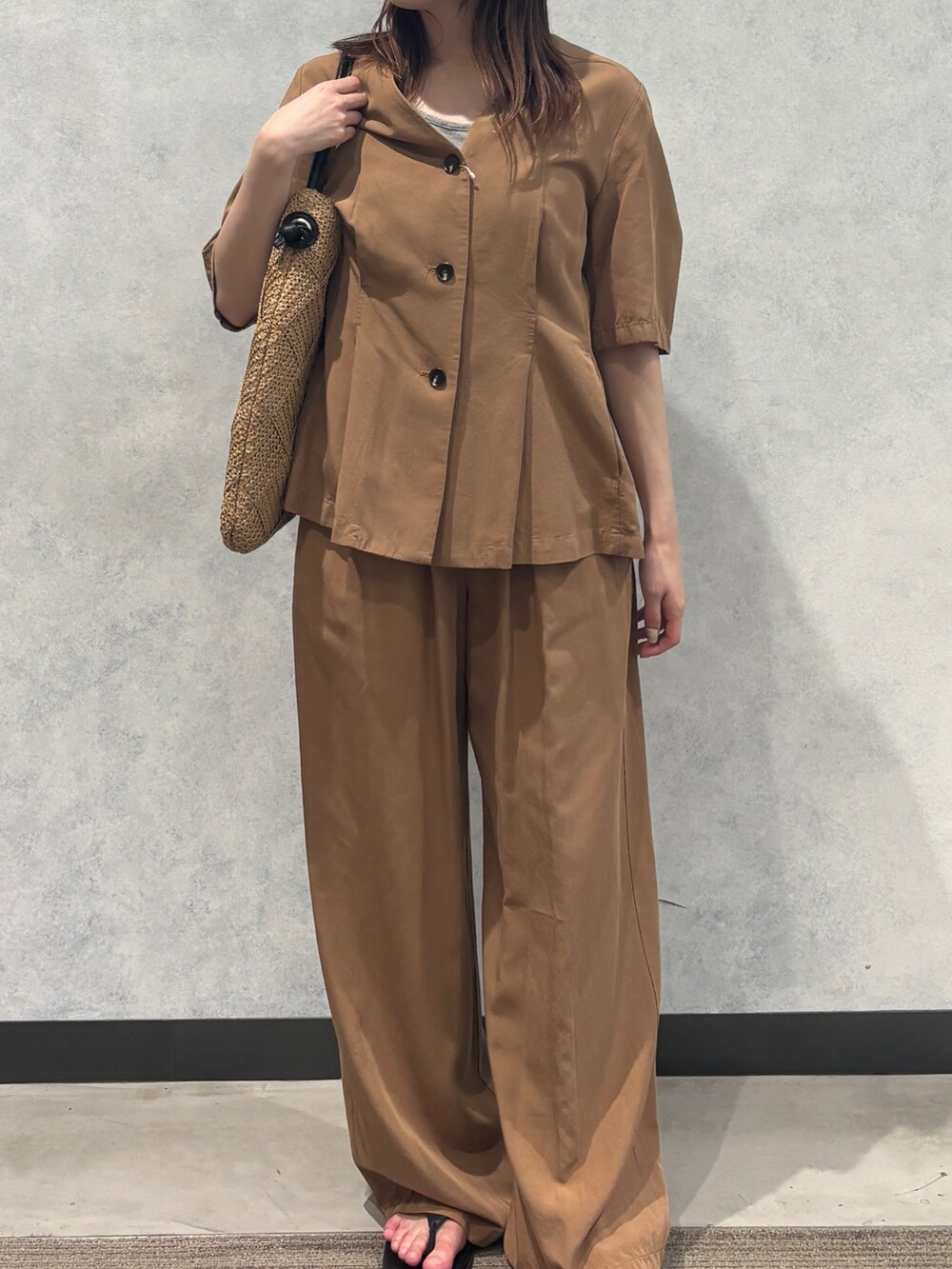 ベージュ系のかごバッグ、ブラウン系のその他パンツ、ブラウン系のテーラードジャケットを着用したレディースの夏コーディネートの3枚目の写真