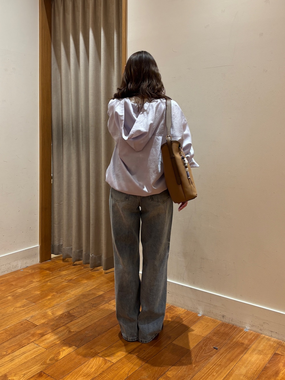 ブルー系のデニムパンツ、ブラウン系のショルダーバッグ、ホワイト系のTシャツ/カットソーを着用したレディースの春コーディネートの3枚目の写真