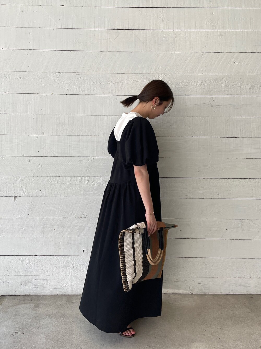 ホワイト系のTシャツ/カットソー、ブラック系のサンダル、グリーン系のトートバッグを着用したレディースの春コーディネートの2枚目の写真