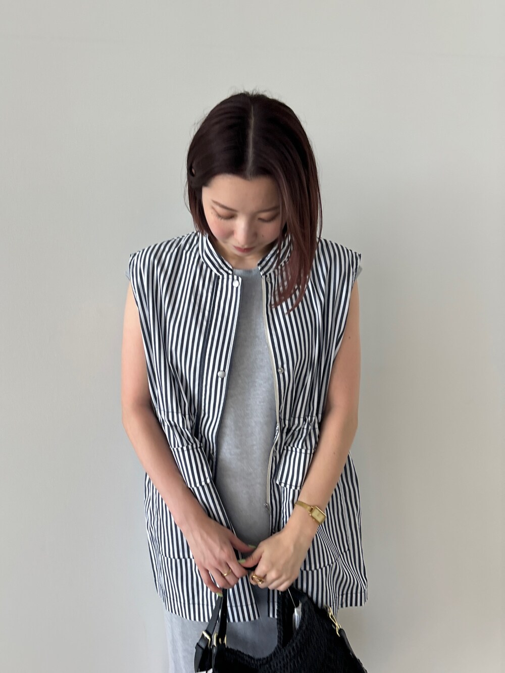 ブルー系のベスト、グレー系のワンピース、ブラック系のかごバッグを着用したレディースの夏コーディネートの3枚目の写真