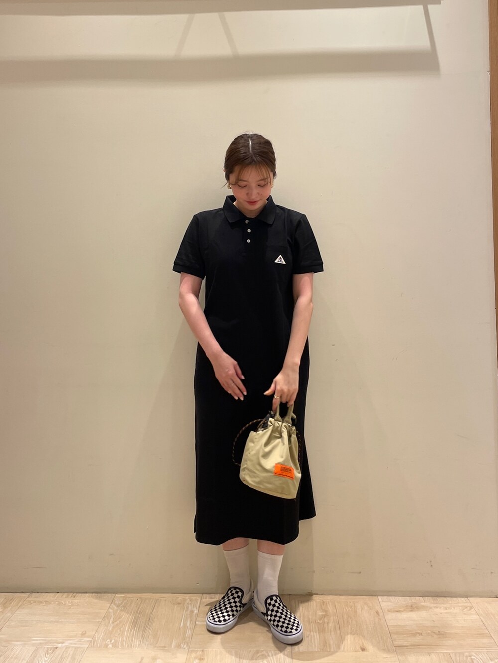 ブラック系のワンピース、ベージュ系のショルダーバッグを着用したレディースの夏コーディネートの2枚目の写真