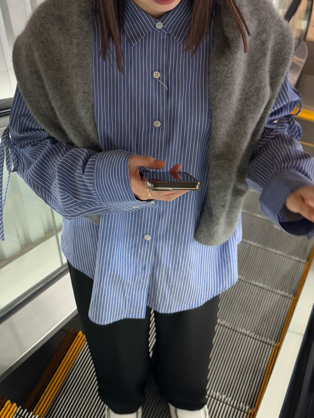 グレー系のニット/セーター、ブルー系のシャツ/ブラウスを着用したレディースの冬コーディネートの3枚目の写真