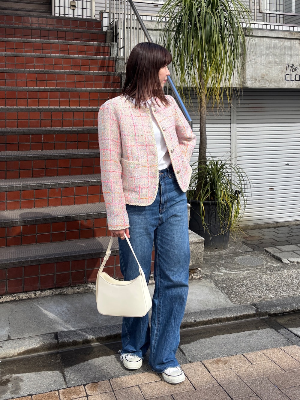 ブルー系のデニムパンツ、ピンク系のノーカラージャケット、ホワイト系のハンドバッグを着用したレディースの冬コーディネートの2枚目の写真