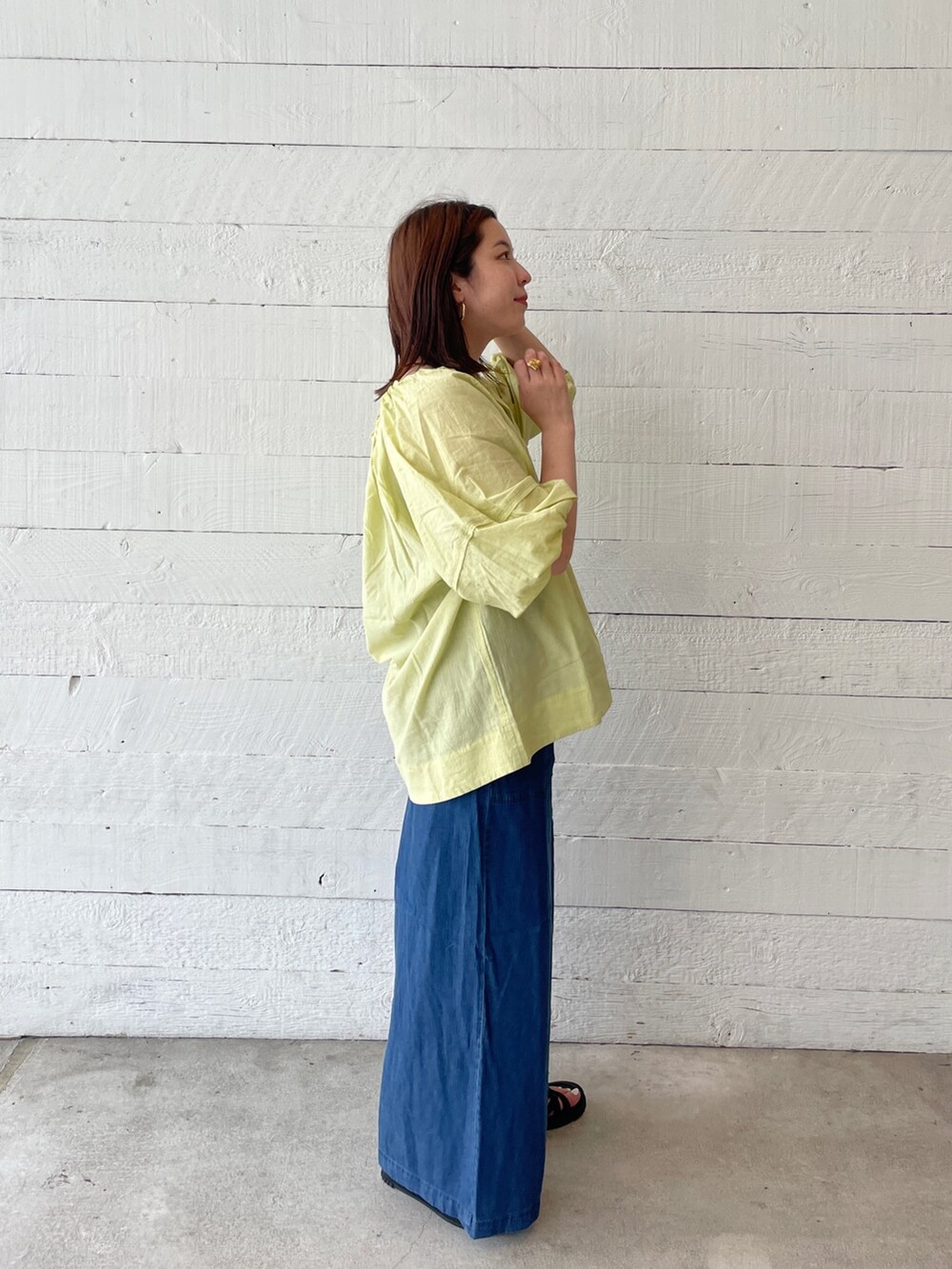 イエロー系のシャツ/ブラウス、ブルー系のその他パンツ、ブラック系のサンダルを着用したレディースの夏コーディネートの2枚目の写真