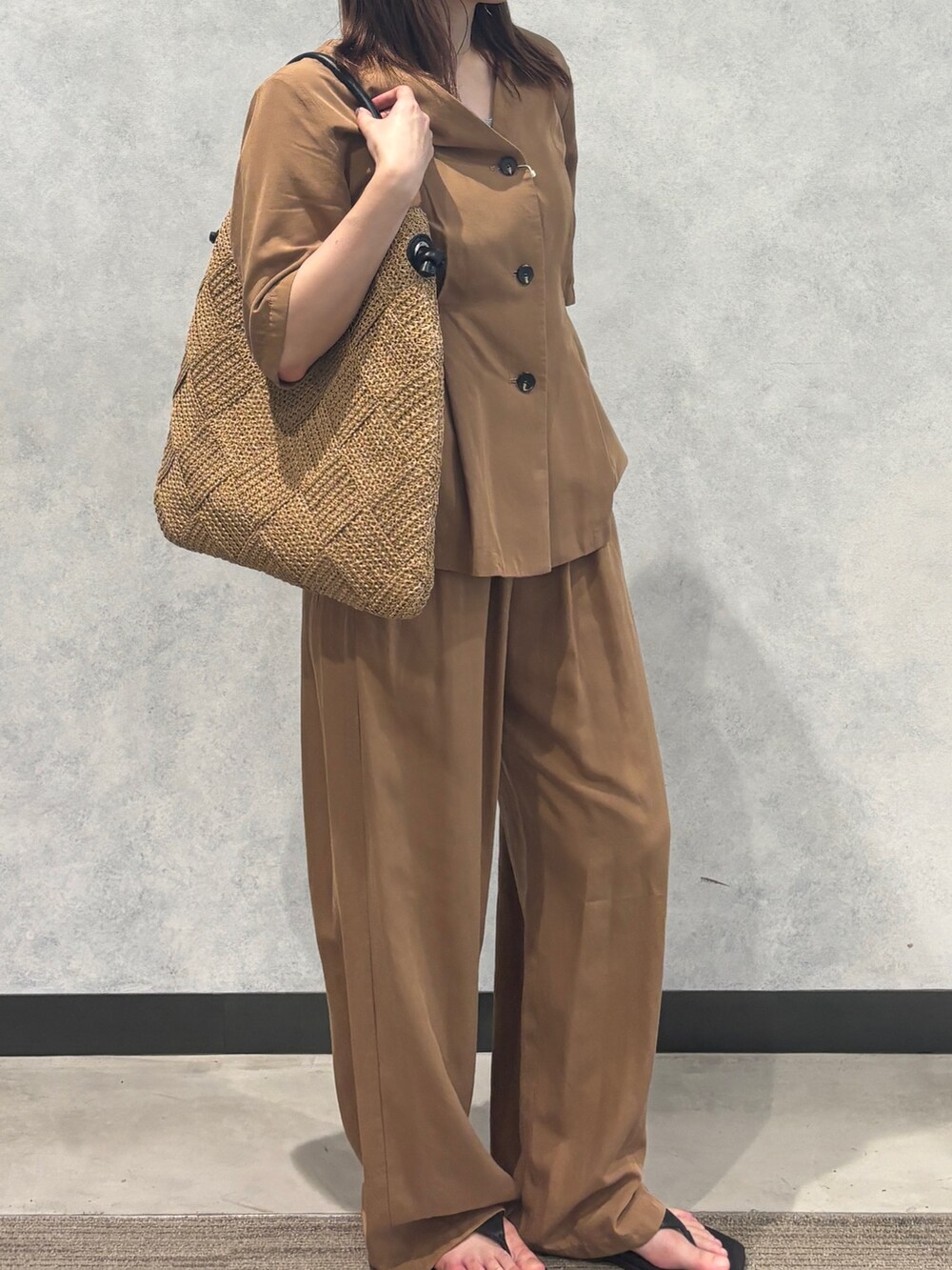 ベージュ系のかごバッグ、ブラウン系のその他パンツ、ブラウン系のテーラードジャケットを着用したレディースの夏コーディネートの2枚目の写真
