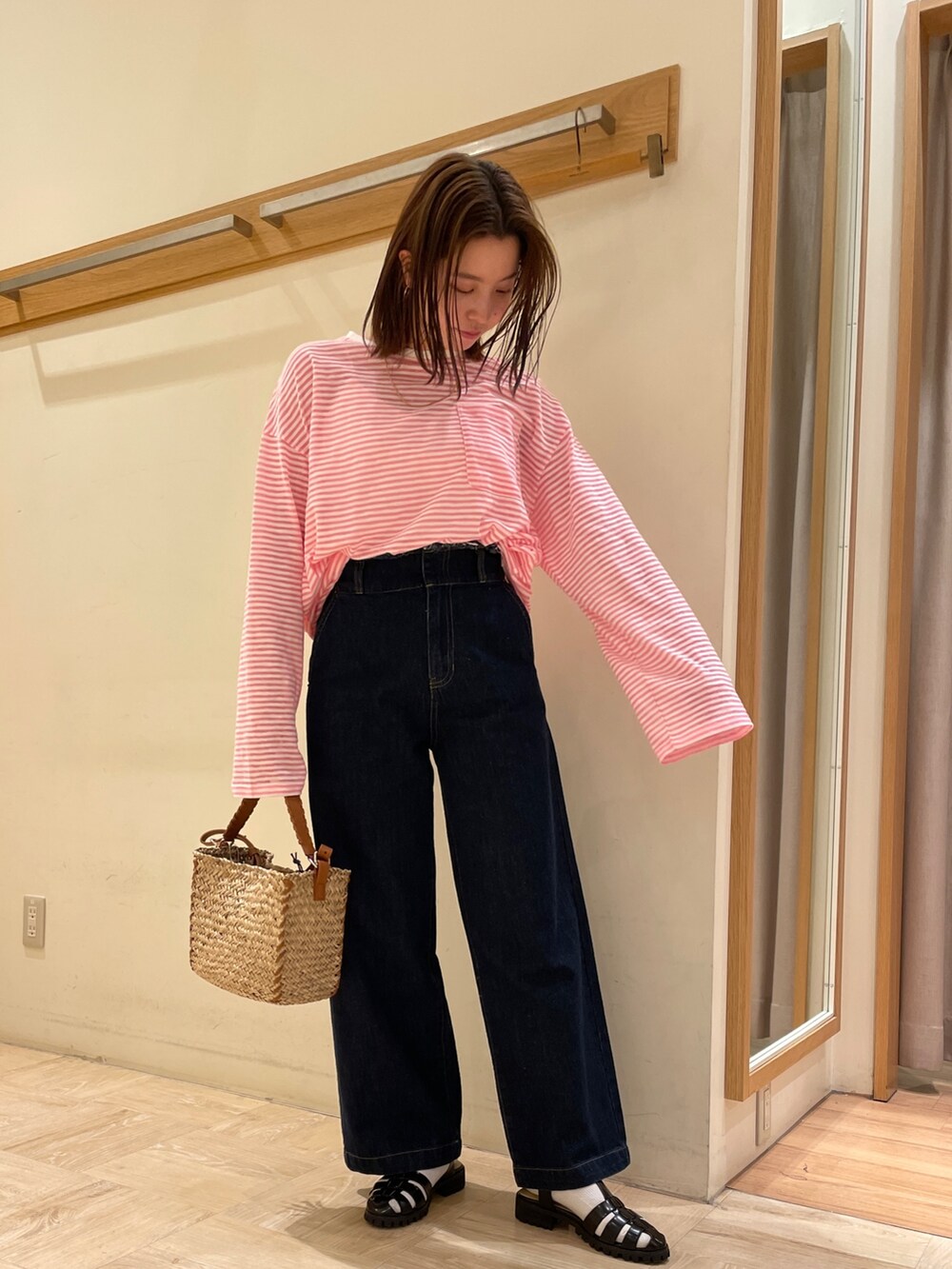 ブラック系のサンダル、ブルー系のデニムパンツ、イエロー系のショルダーバッグを着用したレディースの春コーディネートの2枚目の写真