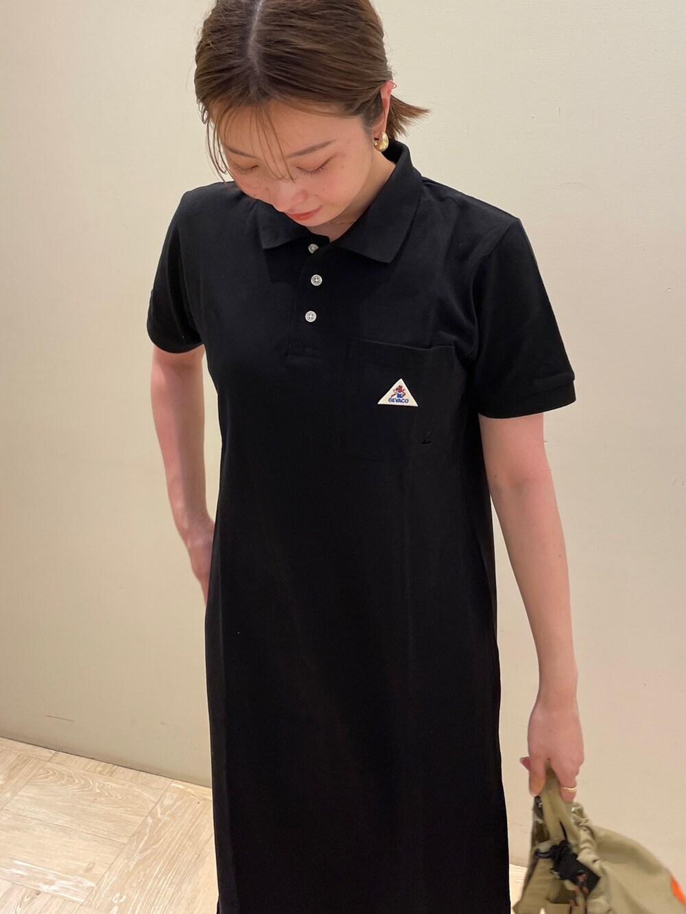 ブラック系のワンピース、ベージュ系のショルダーバッグを着用したレディースの夏コーディネートの3枚目の写真