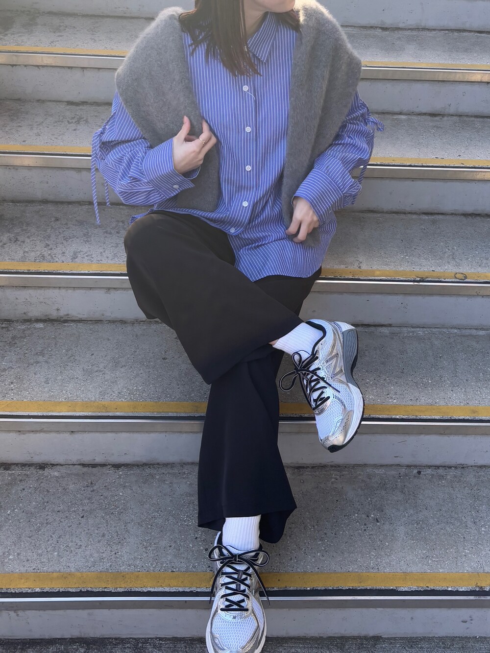 グレー系のニット/セーター、ブルー系のシャツ/ブラウスを着用したレディースの冬コーディネートの4枚目の写真