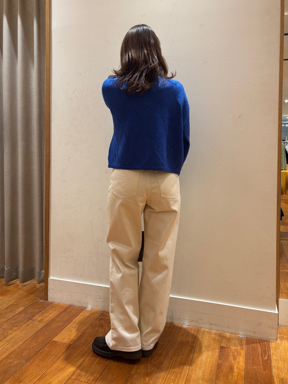 ブルー系のニット/セーター、ホワイト系のデニムパンツ、イエロー系のショルダーバッグを着用したレディースの冬コーディネートの2枚目の写真