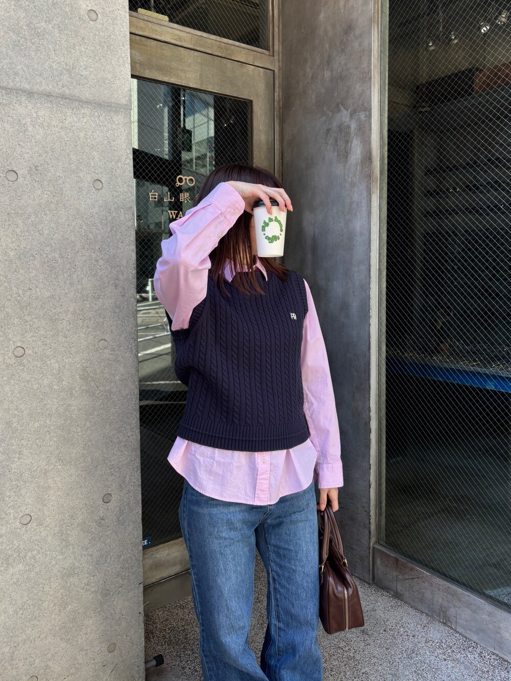 ピンク系のシャツ/ブラウス、ブルー系のベスト、ブルー系のデニムパンツを着用したレディースの春コーディネートの2枚目の写真