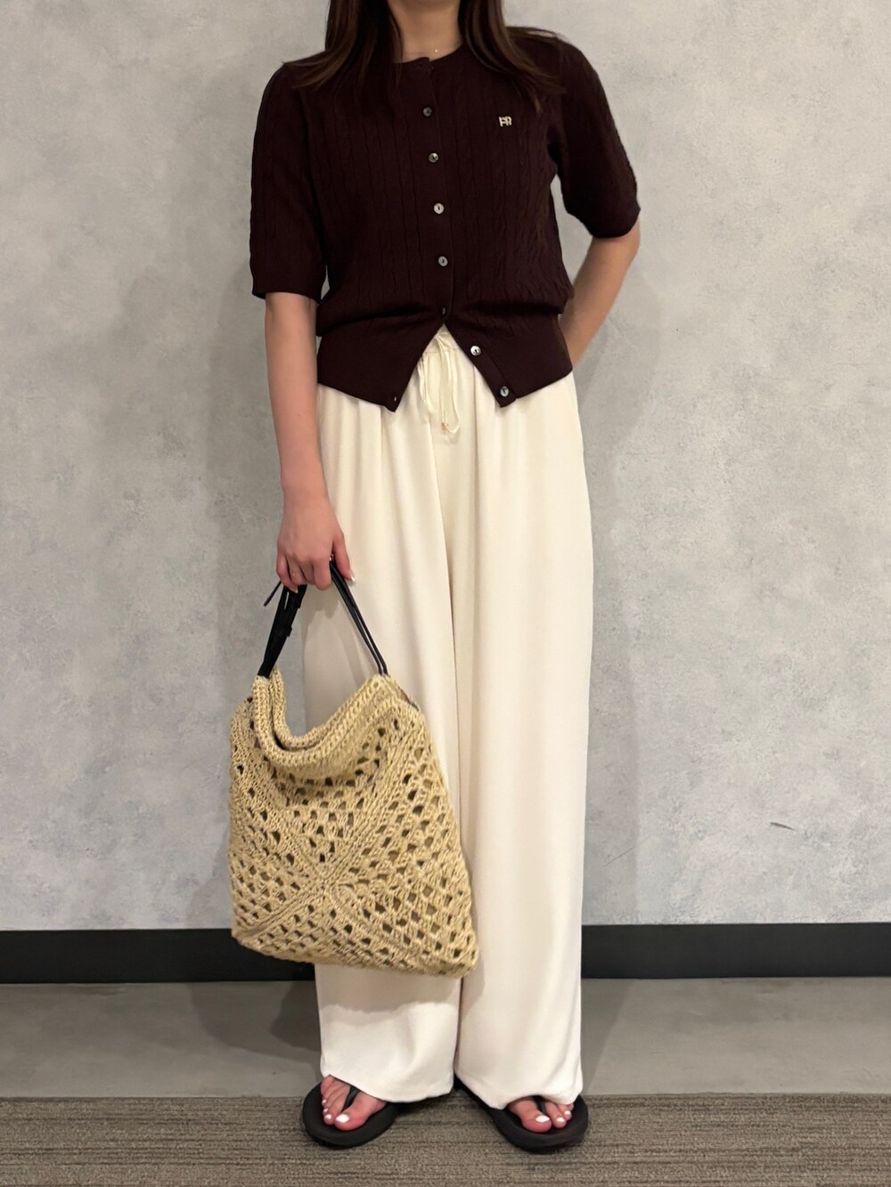 ブラウン系のカーディガン/ボレロ、ホワイト系のその他パンツ、ベージュ系のかごバッグを着用したレディースの夏コーディネートの3枚目の写真