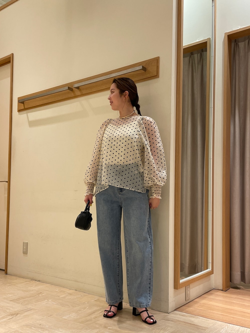 ホワイト系のシャツ/ブラウス、オレンジ系のトートバッグ、ブルー系のデニムパンツを着用したレディースの春コーディネートの2枚目の写真