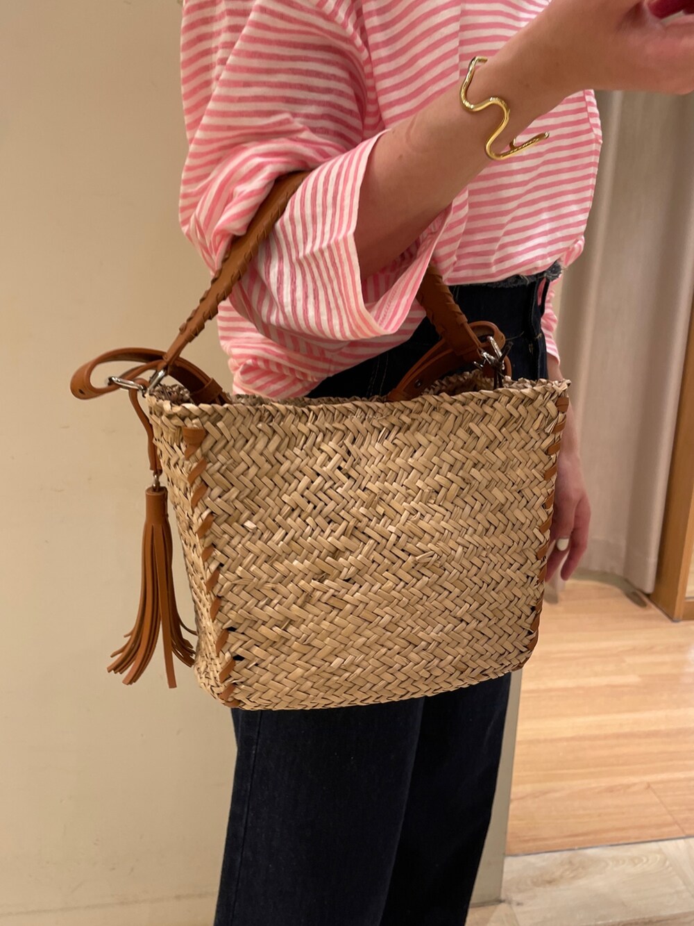 ブラック系のサンダル、ブルー系のデニムパンツ、イエロー系のショルダーバッグを着用したレディースの春コーディネートの3枚目の写真