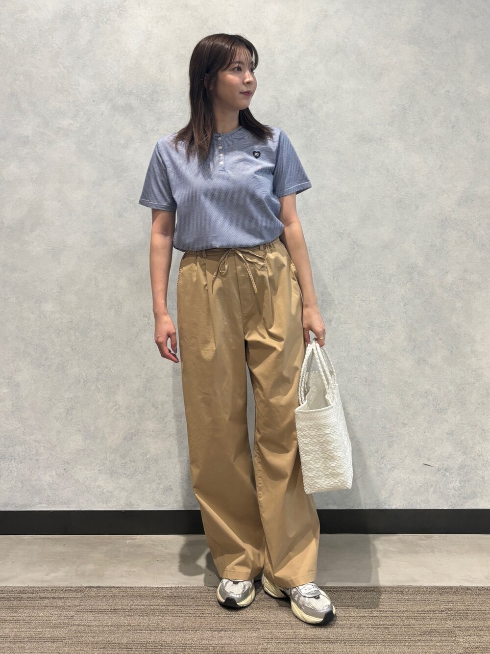 ブルー系のTシャツ/カットソー、ベージュ系のその他パンツ、ホワイト系のかごバッグを着用したレディースの夏コーディネートの3枚目の写真