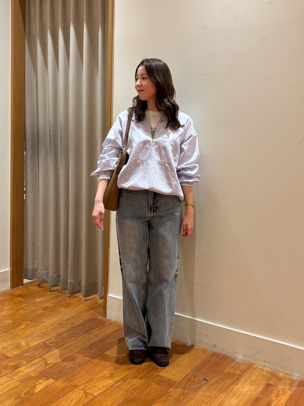 ブルー系のデニムパンツ、ブラウン系のショルダーバッグ、ホワイト系のTシャツ/カットソーを着用したレディースの春コーディネートの2枚目の写真